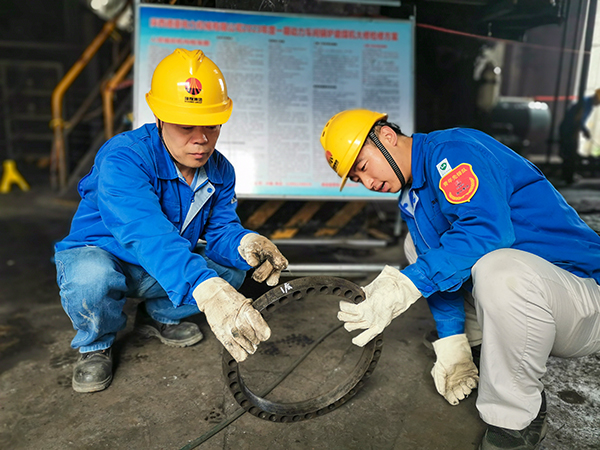 圖三：12日下午14時(shí)，在一期磨煤機(jī)廠房，陜西省技術(shù)能手姬霄給青工張跟潮講解磨煤機(jī)搖臂曲拐內(nèi)環(huán)及動(dòng)作原理。.jpg